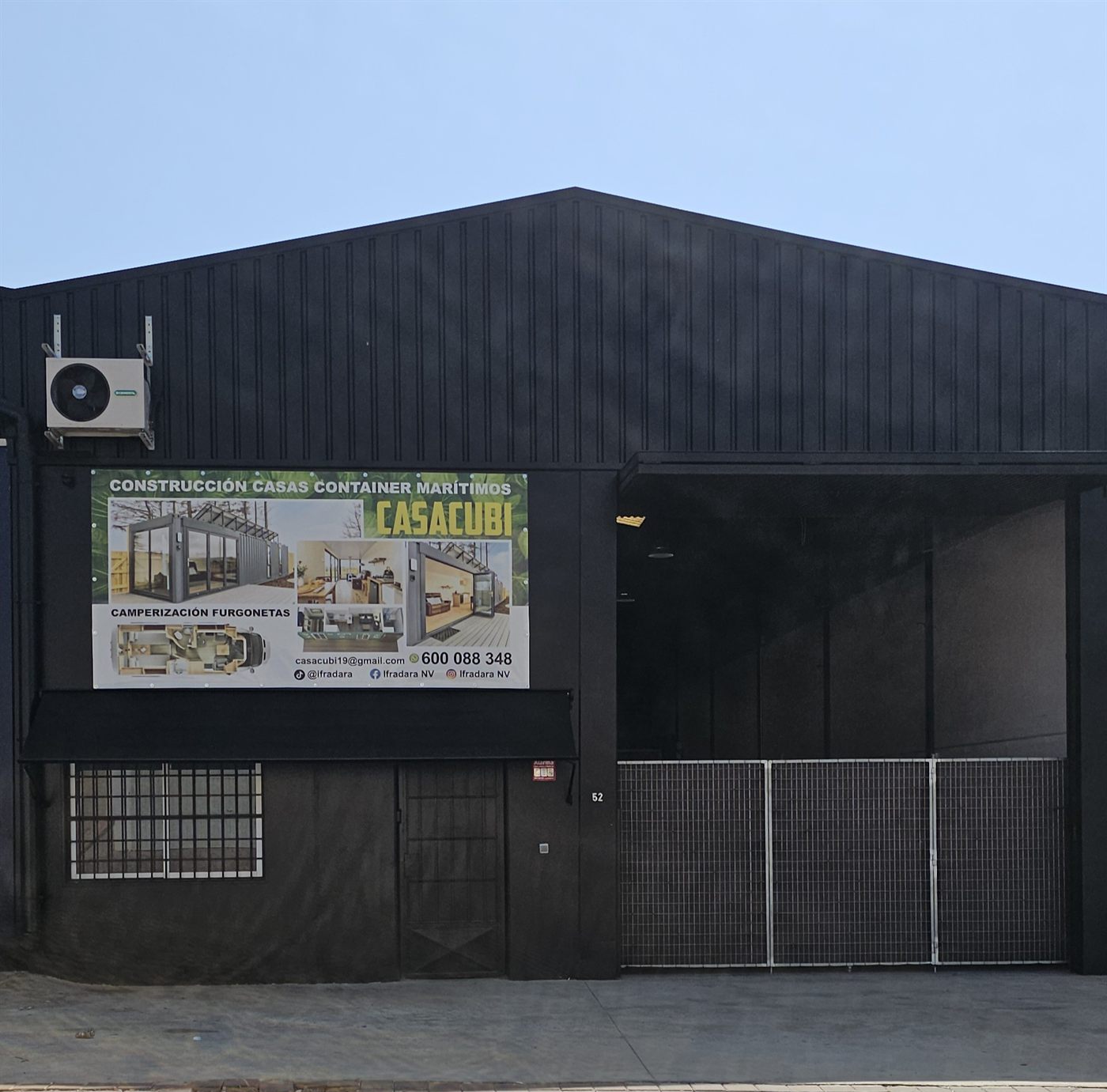 La nave de Casacubi, de chapa negra, con el cartel del taller en el polígono de Águilas